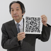 （写真）原さんとQRコード